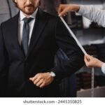 professional-dressmaker-taking-measurements-businessman-260nw-2441310825